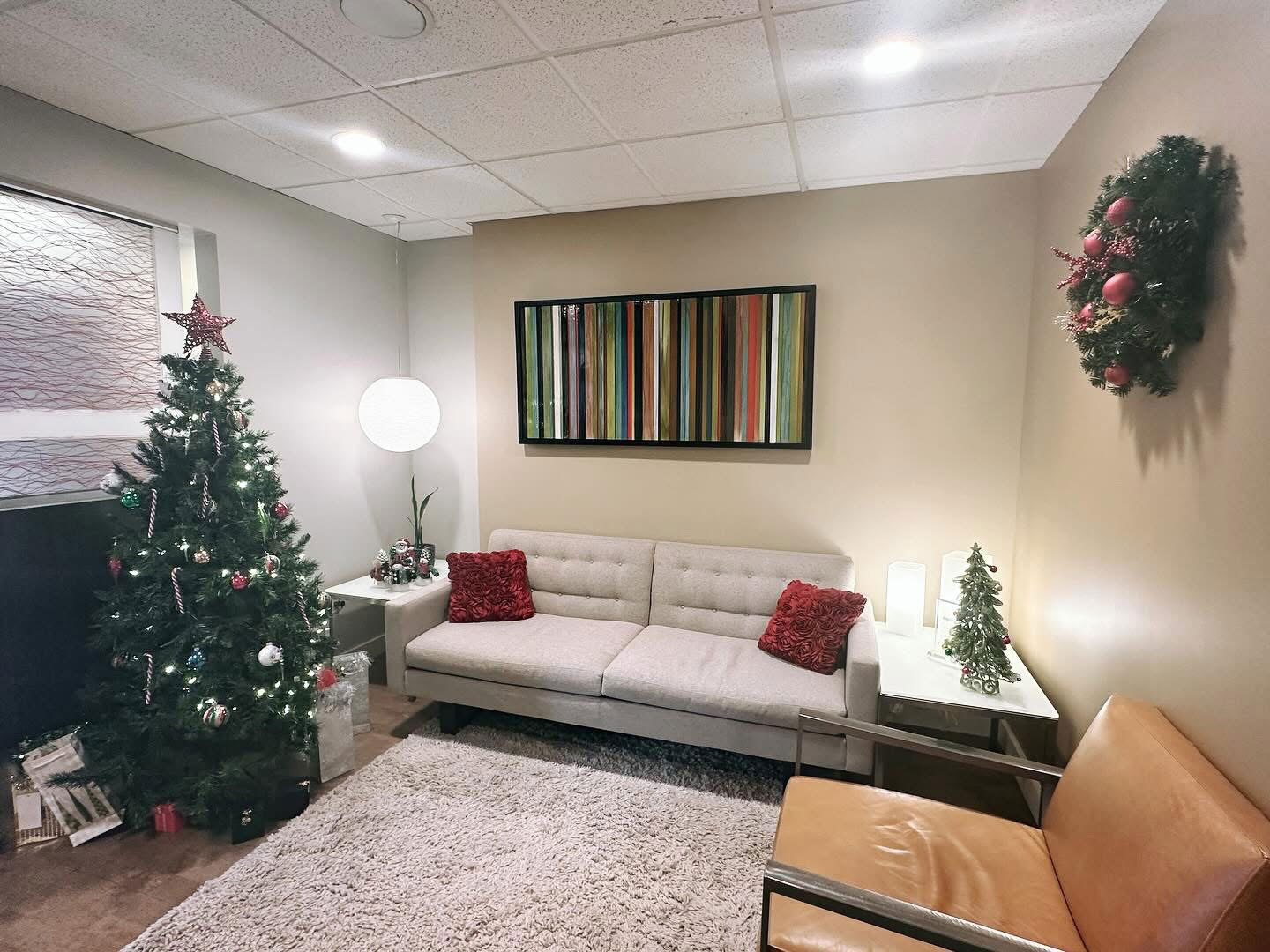The image shows a festively decorated living room with Christmas trees, a couch, and a television.