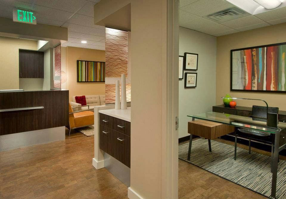 The image shows an interior office space with modern furniture and decor.